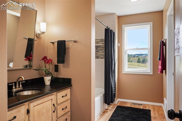 bathroom with vanity, hardwood / wood-style floors, and shower / bath combo