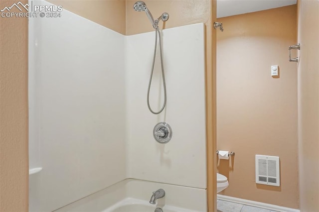 bathroom with tile patterned floors, shower / bathtub combination, and toilet