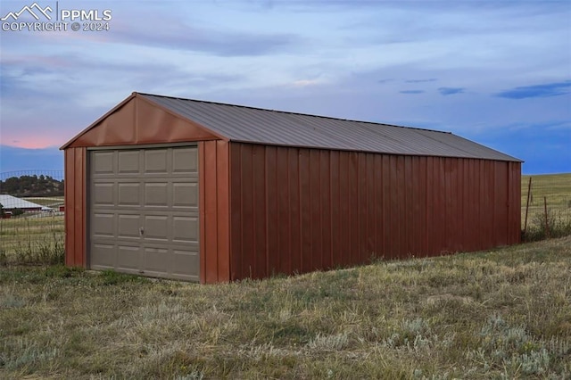 garage at dusk with a yard