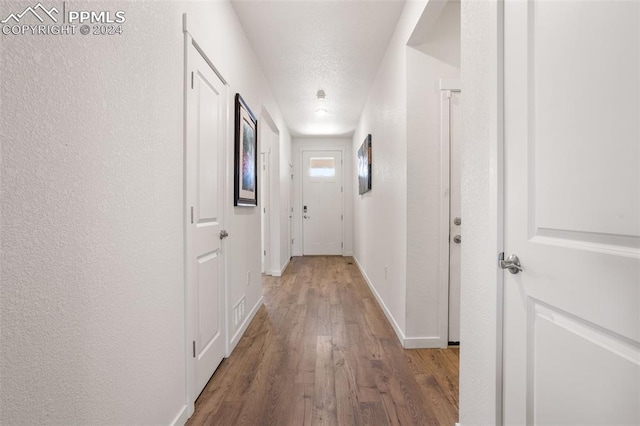 hallway with hardwood / wood-style floors