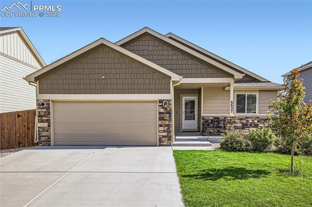 craftsman house featuring a garage and a front yard