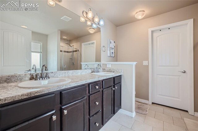 bathroom featuring tile patterned flooring, an enclosed shower, and vanity