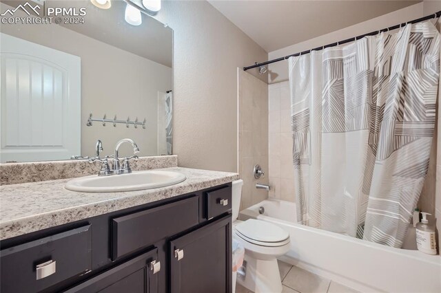 full bathroom featuring tile patterned floors, toilet, shower / bath combo with shower curtain, and vanity