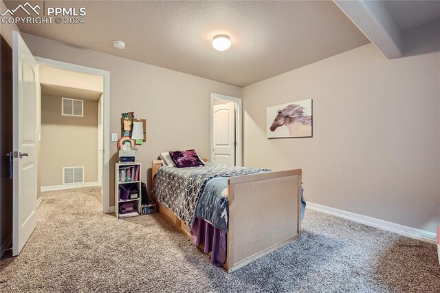 carpeted bedroom featuring a textured ceiling