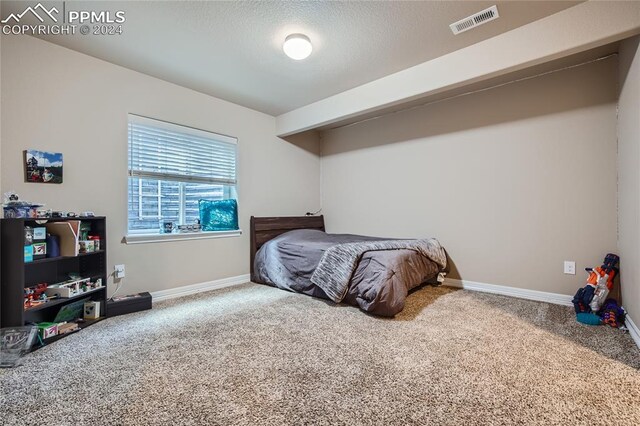 carpeted bedroom with a textured ceiling