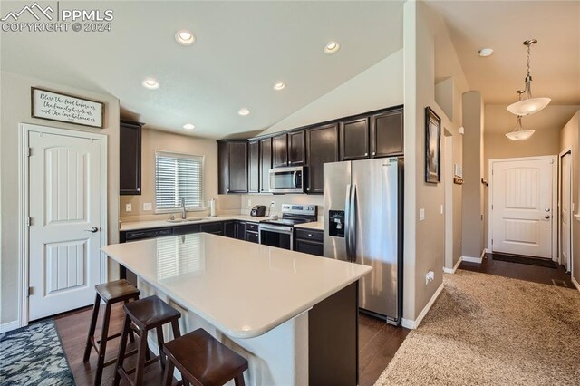 kitchen with a center island, stainless steel appliances, sink, lofted ceiling, and dark hardwood / wood-style floors