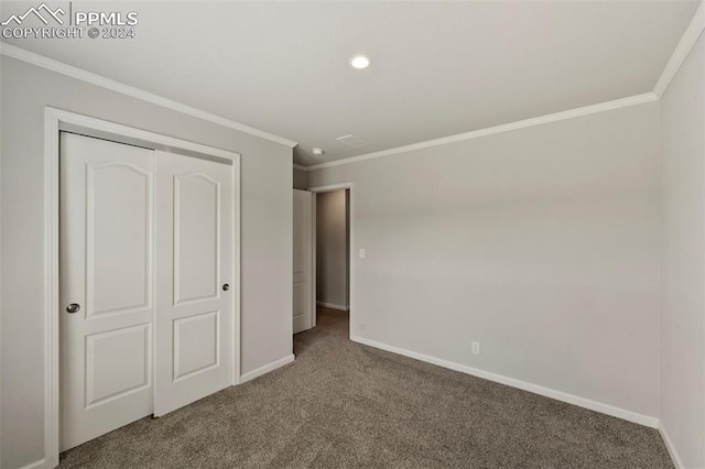 unfurnished bedroom with ornamental molding, a closet, and carpet flooring