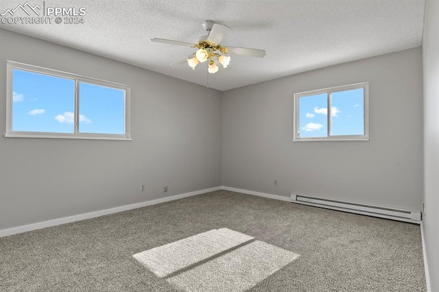 empty room featuring ceiling fan, a textured ceiling, a baseboard heating unit, and carpet