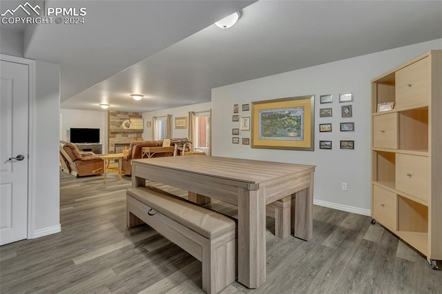 recreation room featuring a stone fireplace and hardwood / wood-style floors