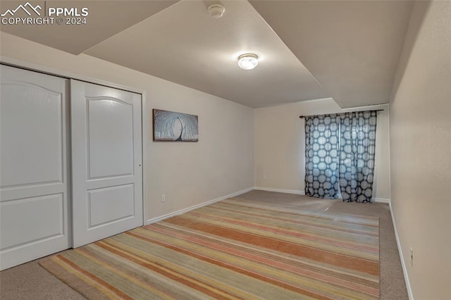 unfurnished bedroom featuring light colored carpet and a closet