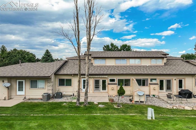 back of property featuring a lawn, a patio, and central AC