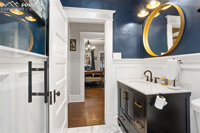 bathroom featuring vanity, hardwood / wood-style flooring, toilet, and a chandelier