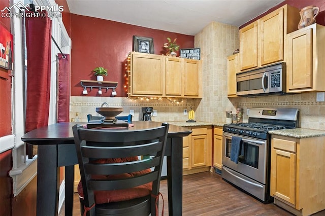 kitchen with light brown cabinets, dark hardwood / wood-style flooring, backsplash, and stainless steel appliances