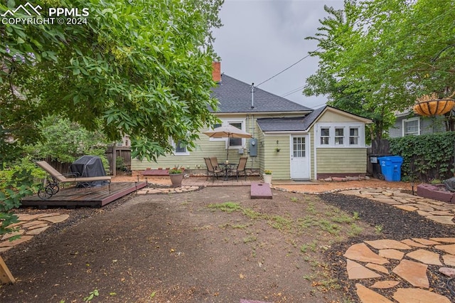 rear view of house featuring a wooden deck