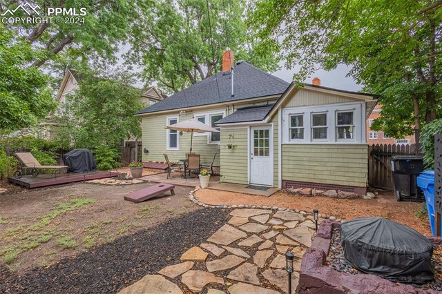 rear view of house featuring a wooden deck and a patio