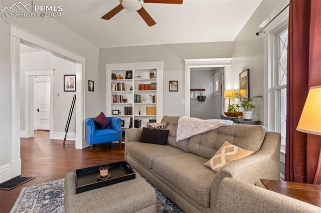 living room with dark hardwood / wood-style floors, ceiling fan, and built in shelves