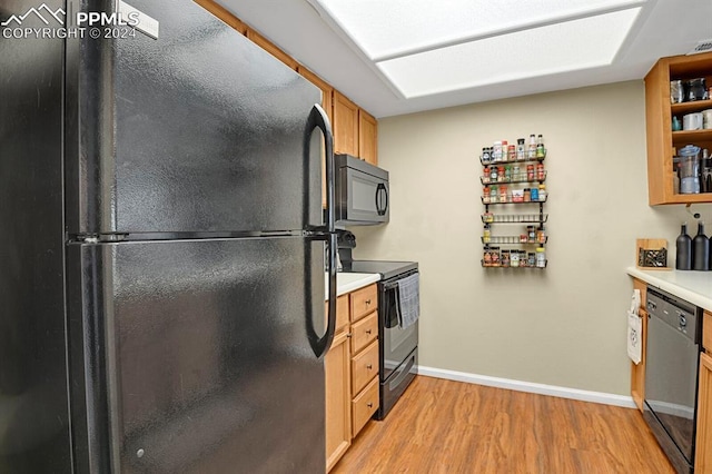 kitchen with light hardwood / wood-style flooring and black appliances