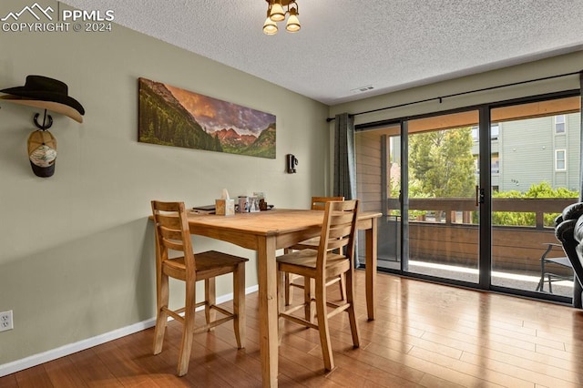 dining area with a textured ceiling and light wood-type flooring