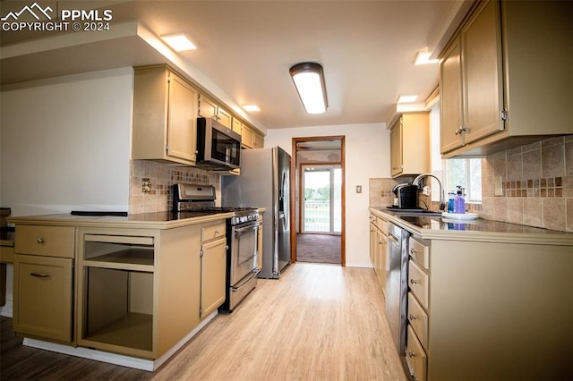 kitchen with sink, stainless steel appliances, light hardwood / wood-style flooring, and backsplash