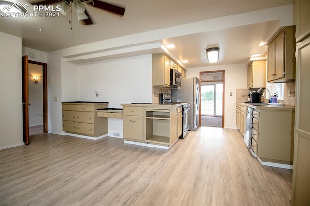 kitchen with ceiling fan, decorative backsplash, appliances with stainless steel finishes, and light hardwood / wood-style floors