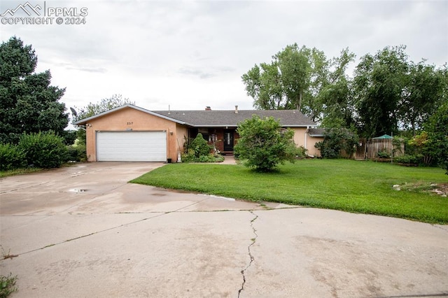 ranch-style house featuring a front yard and a garage