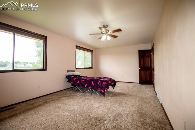 interior space with ceiling fan and light colored carpet