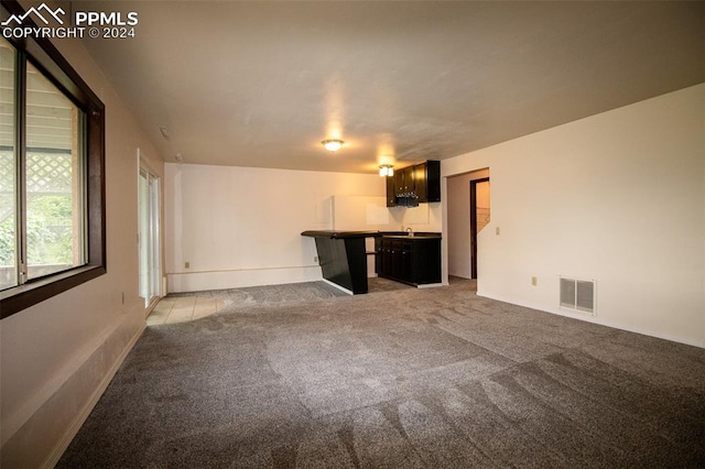 unfurnished living room featuring light carpet