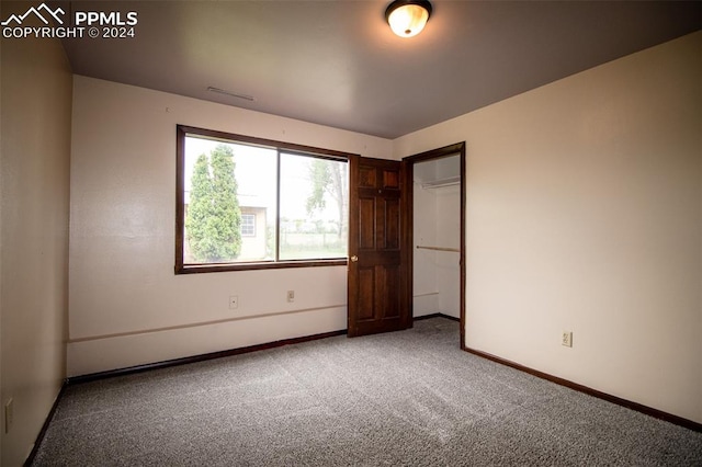 unfurnished bedroom featuring carpet flooring and a closet