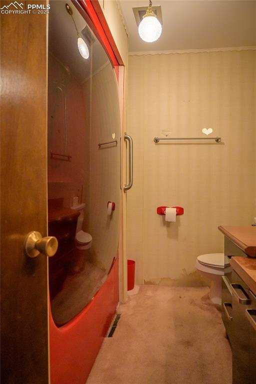 full bathroom with vanity, enclosed tub / shower combo, and toilet