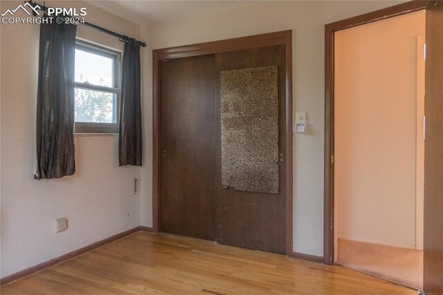 unfurnished bedroom with light hardwood / wood-style flooring and a closet