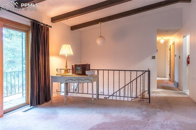 empty room with vaulted ceiling with beams and light carpet