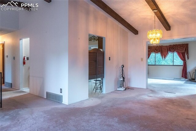 carpeted empty room with beamed ceiling, a towering ceiling, and an inviting chandelier