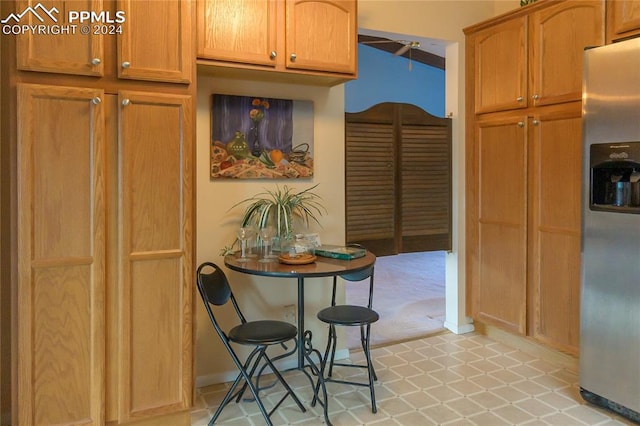 interior space with stainless steel fridge, tile counters, and light tile patterned floors