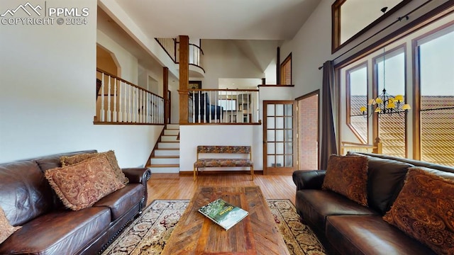 living room featuring a towering ceiling and light hardwood / wood-style flooring