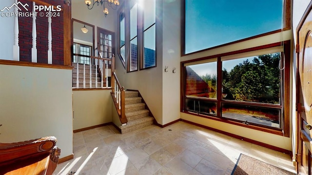 staircase featuring a high ceiling, tile patterned floors, and a chandelier