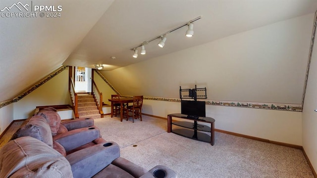 carpeted living room with track lighting and vaulted ceiling