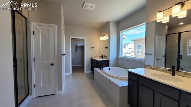 bathroom with tile patterned floors, independent shower and bath, and vanity