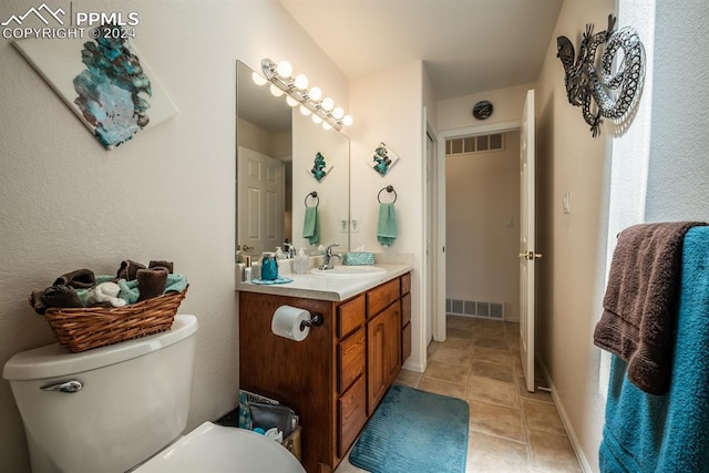 bathroom with tile patterned floors, vanity, and toilet