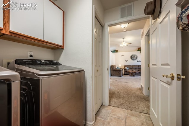 clothes washing area with ceiling fan, light tile patterned floors, cabinets, and washing machine and dryer