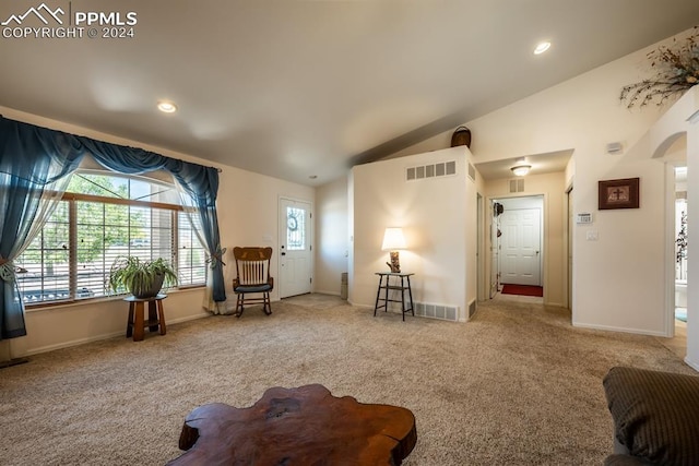 carpeted living room with vaulted ceiling