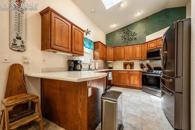 dining area with a skylight, light tile patterned floors, and high vaulted ceiling