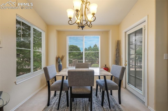 dining area with a notable chandelier, plenty of natural light, and carpet