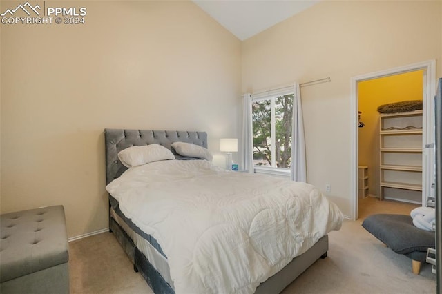 bedroom featuring a walk in closet, vaulted ceiling, and light carpet