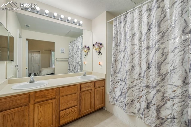 bathroom featuring vanity and shower / bathtub combination with curtain