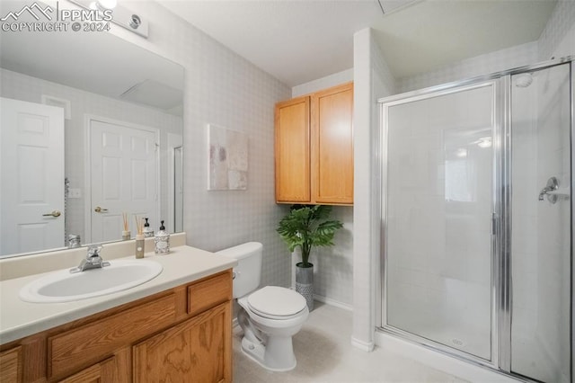 bathroom with vanity, toilet, and a shower with shower door