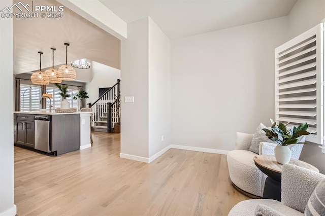 living area featuring light hardwood / wood-style flooring, lofted ceiling with beams, and sink