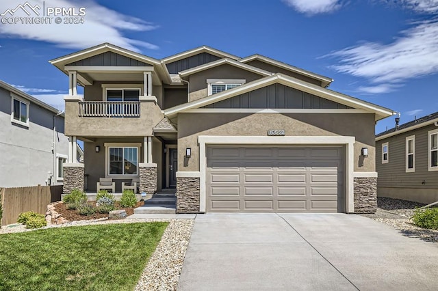 craftsman-style house with a balcony, a garage, and a front lawn