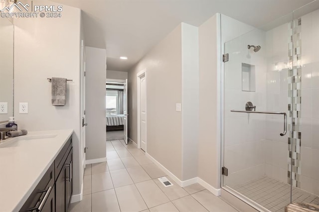 bathroom with tile patterned flooring, vanity, and a shower with door