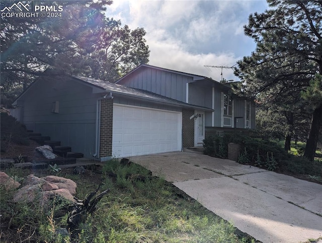 view of front of house featuring a garage, concrete driveway, and brick siding