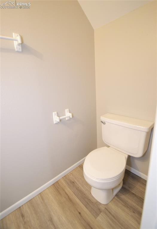 bathroom featuring toilet, lofted ceiling, and wood-type flooring